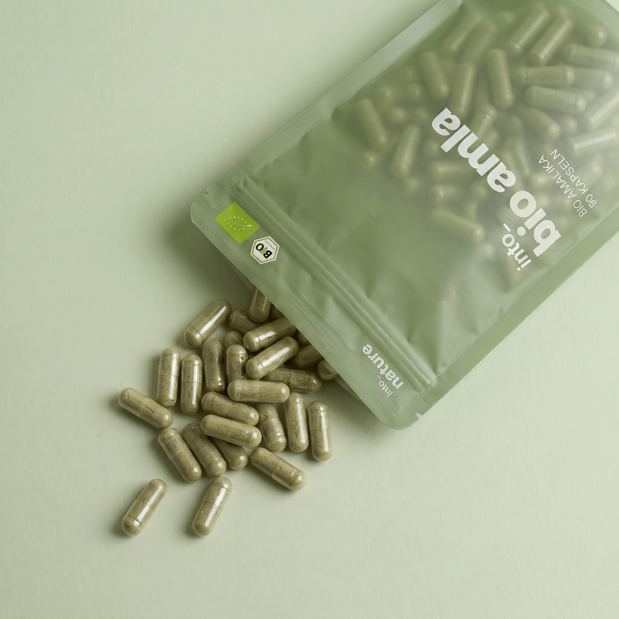 Geöffnete Verpackung mit herausfallenden veganen Bio Amla Kapseln