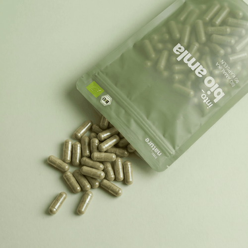 Geöffnete Verpackung mit herausfallenden veganen Bio Amla Kapseln